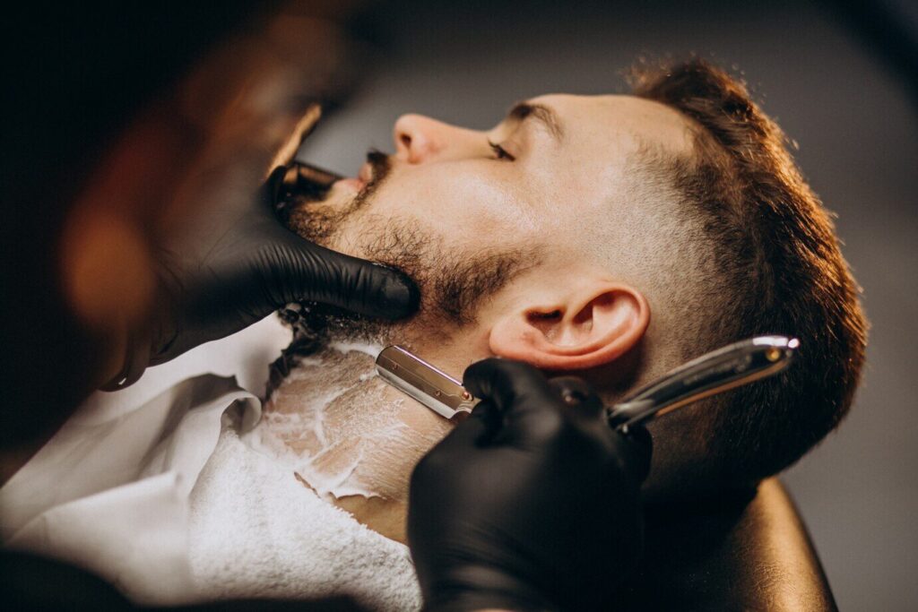 Cliente al que le están afeitando la barba con navaja