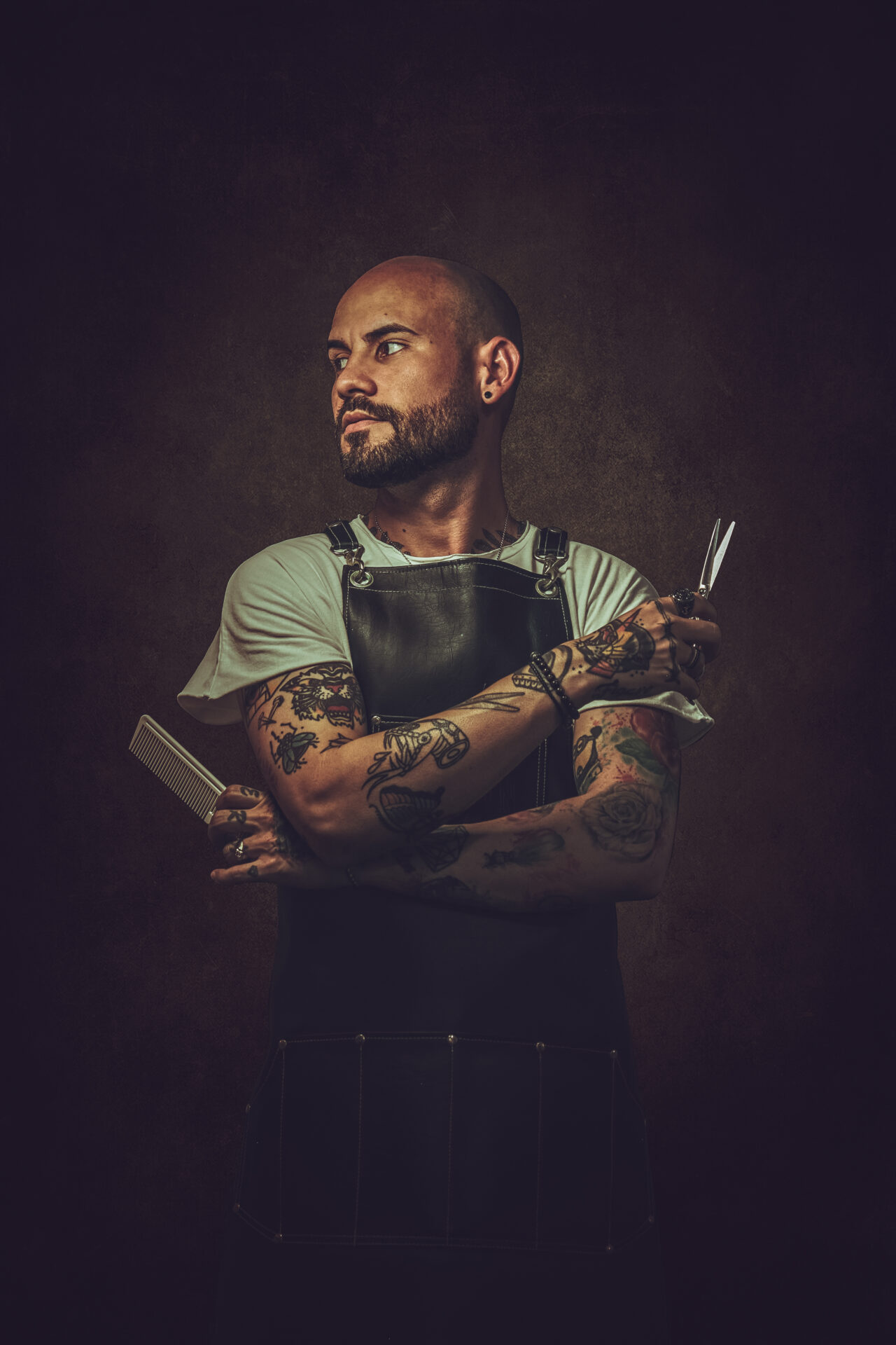 man-holding-scissor-against-black-background Foto del barbero Moha