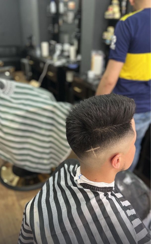 Corte de pelo con degradado y dibujo a un lado de la nuca realizado en Imperial barbershop