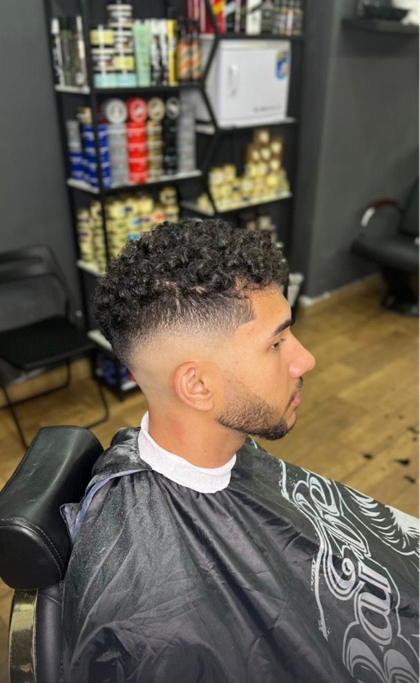 Corte de pelo con degradado manteniendo el volumen y los rizos del cliente, realizado en Imperial Barber shop