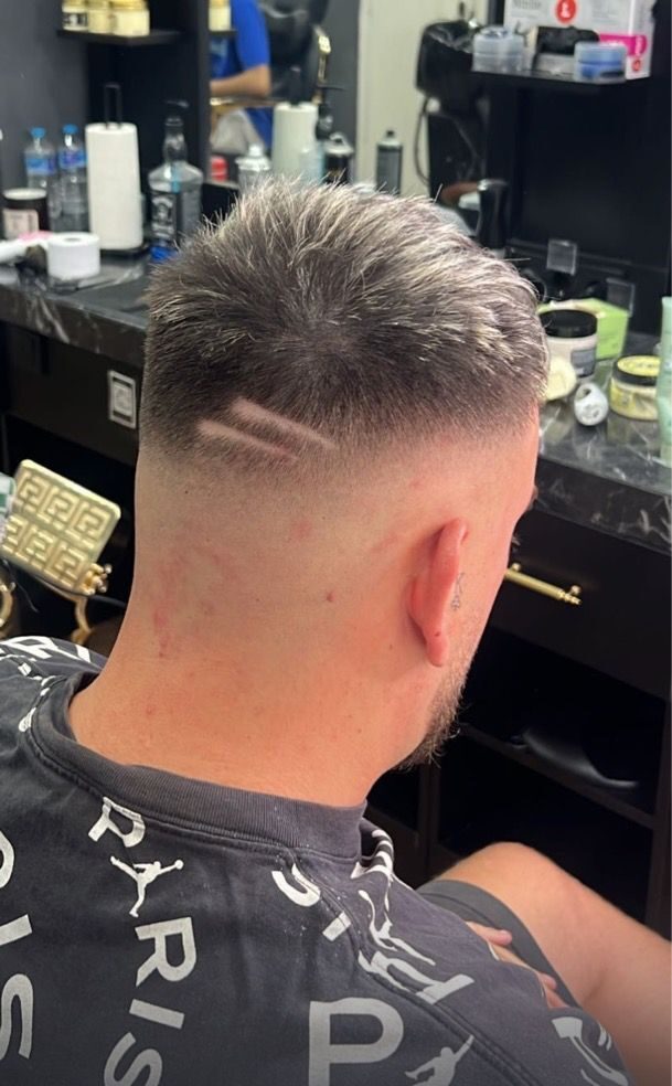 Corte de pelo con degradado y dibujo a un lado de la nuca realizado en Imperial barbershop