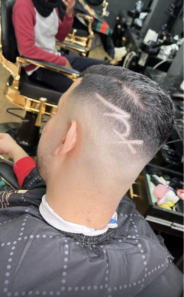 Corte de pelo con degradado y dibujo a un lado de la nuca realizado en Imperial barbershop